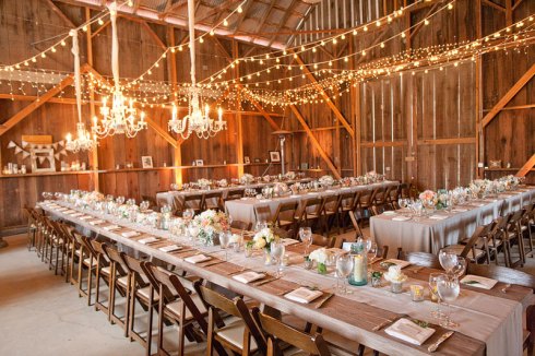  indoor or outdoor wedding reception with long tables and twinkle lights